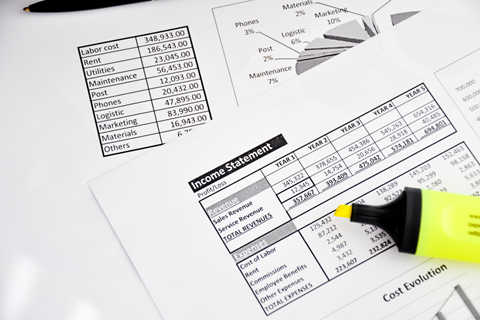 Income statement analysis on sheet of paper next to a yellow highlighter